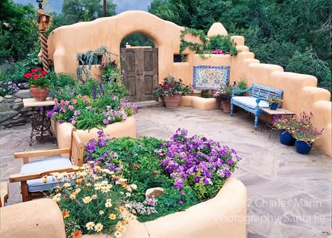 Susan Blevins of Taos, New Mexico, created an elaborate home garden featuring containers, perennial beds, a Japanese themed path and a regional style that reflects the Spanish and pueblo architecture of the area.  The front patio is embellished with a blue bench and colorful container plantings. Adobe Home, New Mexico Homes, Spanish Garden, Taos New Mexico, Adobe House, Mediterranean Home Decor, Cob House, Spanish Style Homes, Hacienda Style