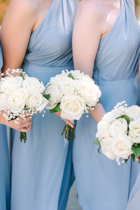 Bridesmaids are wearing light blue dresses while holding white flower bouquets. Bridesmaid Floral Bouquet, Bridal Bouquet White And Blue, Simple White Bride Bouquet, White Flowers For Bridesmaids, White Flowers Bridesmaid Bouquet, Light Blue Bridesmaid Bouquet, Bridesmaid Bouquet Ideas Simple, White Wedding Bouquets Bridesmaid, Wedding Bouquets With Baby Breath