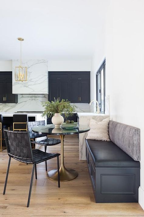 Gold and black dining space with a black built-in bench adorned with a stripe cushion and black woven leather dining chairs in an open concept dining space. Black Leather Dining Chairs, Banquette Seating In Kitchen, Kitchen Banquette, Kitchen Confidential, Transitional Dining Room, Instagram Kitchen, Banquette Seating, Kitchen Benches, Décor Boho