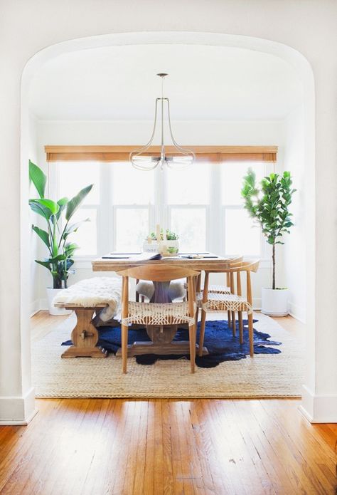 This bright airy dining room is made complete with wooden dining table and chairs, bench seating overlaid with a fur throw, textured area rug and a modern metal chandelier. Scandinavian Dining Room, Scandinavian Dining, Rug Dining Room, Layered Rugs, In The Corner, The Dining Room, Dining Room Inspiration, White Rooms, Dining Room Design