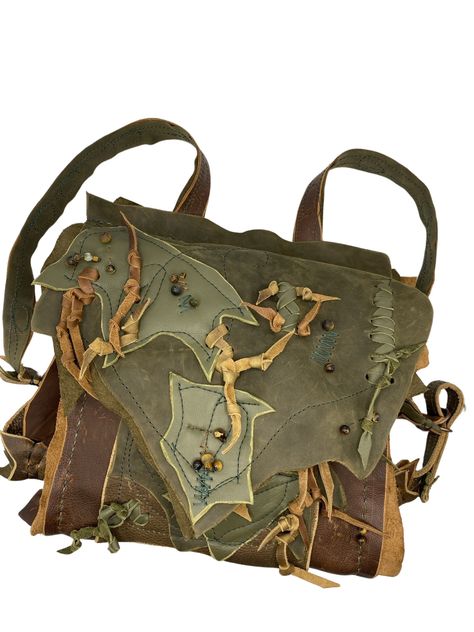 This backpack is a made to order piece please see approximate ship date.  This backpack is an artful piece with lots of leafy details and soft beautiful leather. Made with midweight conditioned leather in brown and olive brown, soft hunter green and moss green accent pieces, this bag is durable, practical and glamorous. The main compartment has an inside and outside pocket. The leafy lid folds over the bag and has two clips to use depending on contents. The inside also has a strap and d rings for keeping contents secured.  The pictured bag has tigers eye tied into the waxed thread but the bag can be made without the gems. Strips of leather have been woven through the piece in whimsical ways. The inside front has a leather leaf dangle stitched into the pocket.  The shoulder straps are conne Witchy Goblincore, Art Bags, Handmade Leather Backpack, Fair Outfits, Leather Leaf, Art Bag, Brown Leather Bag, Louisville Ky, Boho Bag