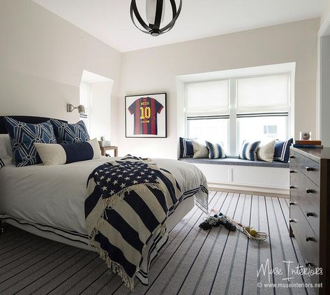 Grown up boy's bedroom features a black curved headboard on bed dressed in white and black bedding and blue pillows placed top a blue and gray rug facing a dark wood 4 drawer dresser. Boys Soccer Themed Bedroom, Soccer Room Ideas For Boys, Boys Soccer Bedroom, Soccer Themed Bedroom, Window Seat Nook, Soccer Bedroom, Room Bedroom Ideas, Soccer Room, Built In Window Seat