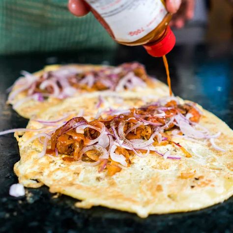 The Kolkata egg roll, also known as kathi roll, can be traced back to the restaurant Nizam’s in Kolkata. It was invented in the 20th century, back when Kolkata was the capital of the British Empire. The story goes that British customers did not want to use their hands to eat kebabs, and so the staff at Nizam’s decided to roll the meat up in flaky, buttery parathas. In its early days, Nizam’s was a stall that served kebabs and parathas; it only became a proper restaurant in 1932.  The egg ro Kolkata Egg Roll, Kolkata Food, Bengali Fish Curry, Roasted Lentils, Kathi Roll, Spicy Chutney, The British Empire, Egg Roll Recipes, Best Street Food