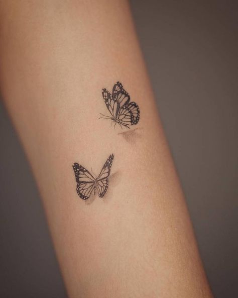 Micro-realistic butterflies tattooed on the upper arm. Side View Butterfly Tattoo Simple, Micro Realistic Butterfly Tattoo, Ingenue Tattoo, Wrap Around Forearm Tattoo Women Butterflies, Floating Butterfly Tattoo, Butterflies Tattoo Wrist, Butterfly Tattoo Closed Wings, Inner Arm Butterfly Tattoos For Women, Perched Butterfly Tattoo