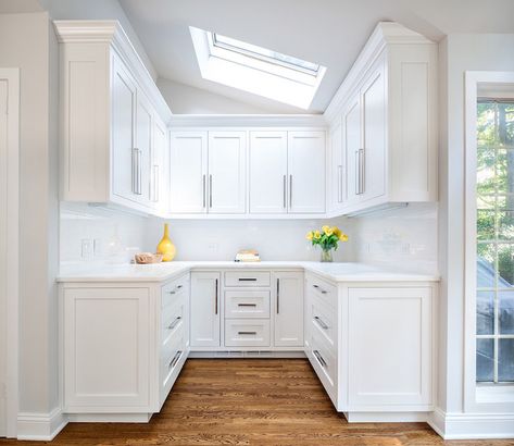 Sun filled butler's pantry boasts a sloped ceiling fitted with skylight over a U shaped butler's pantry featuring white shaker cabinets adorned with long hardware paired with white quartz countertop and a white linear tiled backsplash atop oak wood floors with a Minwax Dark Walnut Stain. U Shaped Pantry, Pantry Floor, To Ceiling Cabinets, Ceiling Cabinets, Traditional Bedroom Design, White Kitchen Countertops, White Kitchen Splashback, Floor To Ceiling Cabinets, White Kitchen Table