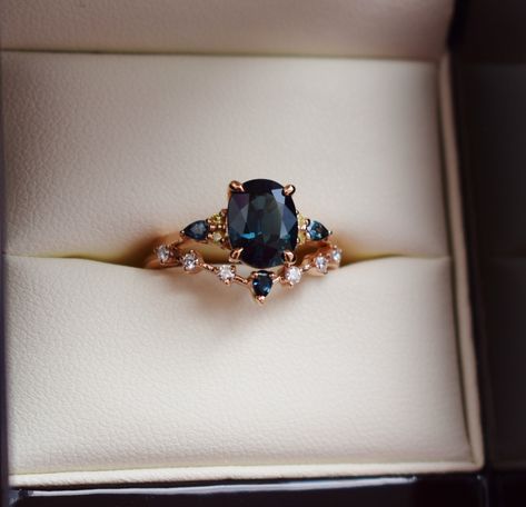 "Welcome our 2022 collection! Oval cut blue green teal sapphire engagement ring set by Eidelprecious. The ring is a twist on our bestseling Campari design. It features a 2.5 oval sapphire, amazing teal blue green color. Displays some color change. Very unique and rare one of a ring Our newest 2022 version of Campari setting features 4 round yellow diamonds and 2 pear teal sapphires. 14k Rose gold. Complimentary wedding band was designed specifically for this collection. Made in 14k rose gold, it Eternity Ring Engagement, Gold Sapphire Rings, Sapphire Engagement Ring And Wedding Band, Vintage Sapphire Ring Engagement, Sapphire Ring Set, Navy Engagement Ring, Oval Cut Sapphire Ring, Oval Sapphire Wedding Ring Set, Sapphire Engagement Ring Gold Band