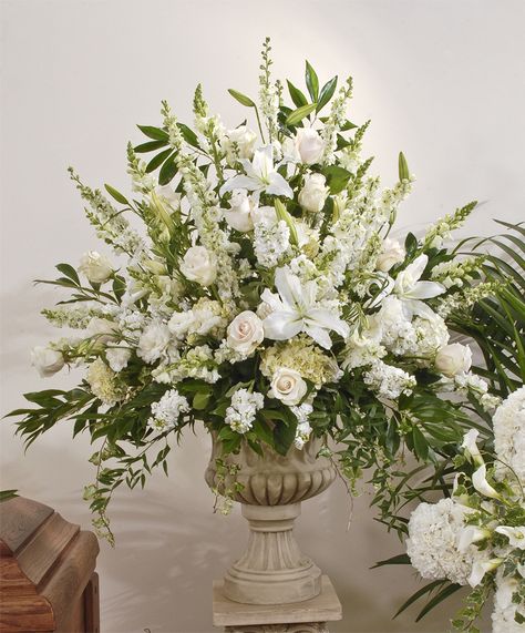 An abundance of fresh flowers including lilies, roses, snapdragons, delphinium, hydrangea, lisianthus, stock and larkspur are incorporated into this arrangement. It's a large arrangement that will be made in a plastic container, and displayed inside the urn, on a column for the memorial service.  The urn and column are not included in the purchase price of the flowers, and will be returned to Zeidler's.  sympathy, deceased, funeral, funeral home, flowers, casket spray, sprays, caskets, fami Classic Flower Arrangements, Pulpit Flower Arrangements Church, Tall Floral Arrangements For Home, Large Flower Arrangements For Home, Urn Floral Arrangements, All White Floral Arrangements, Church Flower Arrangements Altars Ideas, Memorial Flowers Arrangements, Urn Flower Arrangements