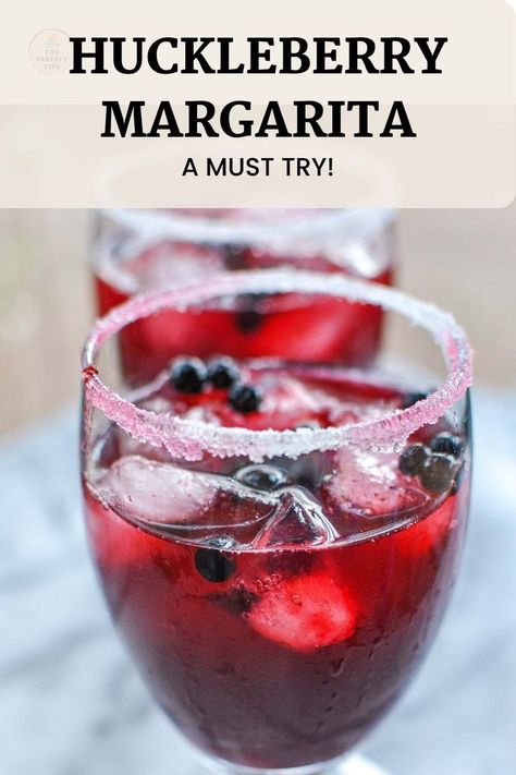 bright red drink on the rocks with fresh huckleberries and a sugar rim Huckleberry Vodka Recipes, Fresh Huckleberry Recipes, Huckleberry Lemonade Recipe, Huckleberry Syrup Recipe, Margarita Recipes On The Rocks, Huckleberry Margarita, Recipes Date Night, Date Night Dinner Recipes, Lime Simple Syrup