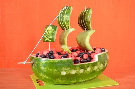 How to Carve a Watermelon Into a Pirate Ship By Jessica Mahoney, eHow Contributor  31   Share   Tweet   Stumble   Share 32Found This Helpful A watermelon carved to look like a pirate ship makes a charming and refreshing addition to the spread for a summertime cookout or pirate-themed birthday party. This project requires an oblong watermelon to achieve the elongated shape of a pirate ship, although you can choose from multiple pirate ship shape options. Use the pirate ship watermelon as ... Pirate Ship Watermelon, Fruit Boat, Watermelon Boat, Watermelon Ball, Pirate Themed Birthday Party, Watermelon Crafts, Deco Fruit, Pirate Themed Birthday, Watermelon Art