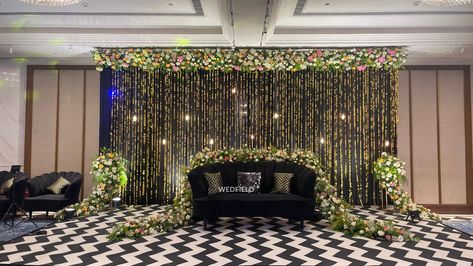 Ring Ceremony @tajmahalhotelnewdelhi black and gold theme decor with a touch of magic in every corner. Decor by @wedcellevents About decor - Triangle-shaped Photo Booth with LED Strip lighting and a Gold Sequin Panel on the back Couple Stage featuring a Golden Ladi hanging backdrop adorned with Tungsten Bulbs, and LED Screen Panels on both sides. Bar Structure with Facade . Shimmer Fabric Bar Backdrop featuring "Drunk in Love" Neon Sign and Small Paintings. Glass Katora Shape Arrangement wit... Ring Ceremony Stage, Fabric Backdrop Wedding, Bar Structure, Bar Backdrop, Hanging Backdrop, Fabric Bar, Instagram Ring, Black And Gold Theme, Reception Stage