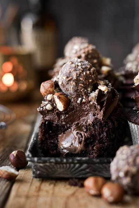 High altitude tested chocolate hazelnut cupcakes, filled with Nutella, frosted with fluffy buttercream, and topped with chopped hazelnuts and Ferrero Rocher truffles. Hazelnut Ganache Recipe, Chocolate Hazelnut Cupcakes, Chocolate Hazelnut Macarons, Chocolate Hazelnut Ganache, Hazelnut Profiteroles, Hazelnut Cupcakes, Fluffy Buttercream, Cupcake Photography, Chocolate Truffle Cake