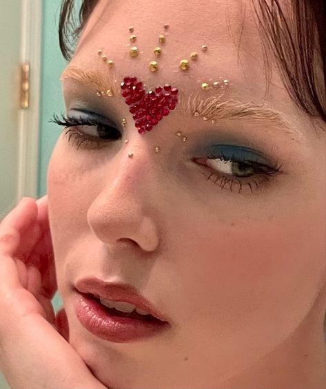 Sacred Heart Makeup, Heart Inspired Makeup, Gemstones On Face, Heart Glitter Makeup, Pearl Face Gems, Heart Makeup Ideas, Heart Eye Makeup Look, Gold And Red Makeup, Heart Make Up