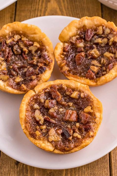 These easy-to-make mini pecan pies are the perfect bite-sized treat. These single-serve pecan pies have a buttery crust and a gooey pecan pie filling made from scratch. This is a great dessert for the Thanksgiving season. Mini Pecan Pies In A Muffin Tin Easy, Small Pies Recipes, Mini Pecan Pies In A Muffin Tin, Small Pecan Pies, Individual Pecan Pies, Miniature Pies, Pie Crust Dessert, Gooey Pecan Pie, Chocolate Chip Pecan Pie