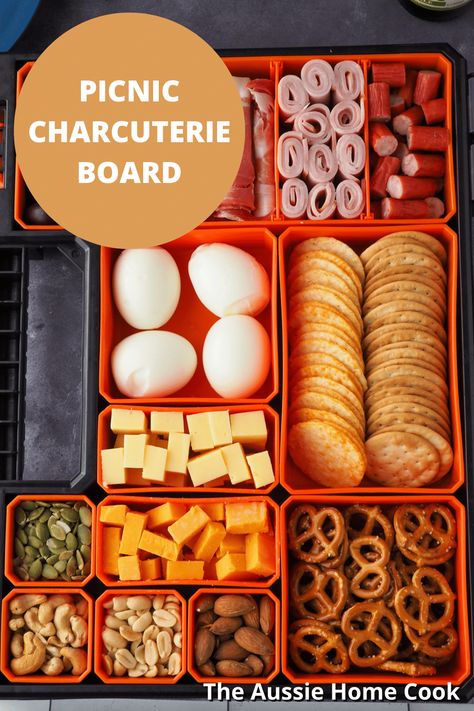 This picnic charcuterie board, or snackle box, makes the ultimate easy and fun portable food. Perfect for a picnic or a camping or fishing trip. Did someone say snack attack? River Float Lunch Ideas, Charcuterie Travel Board, Charcuterie Board For The Beach, Fishing Box Charcuterie, Fishing Snack Ideas, Portable Charcuterie Board Ideas, Lake Day Snack Ideas, Snackle Box Ideas For Boat, Snackle Box Ideas Road Trip