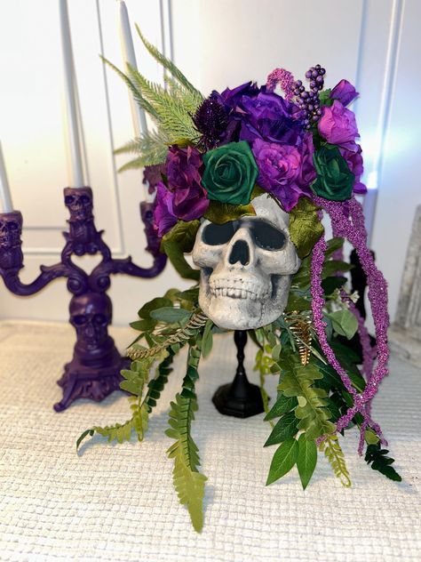 Gorgeous and unique! Beautiful jewel tones of purple and green. Sits on a solid black candlestick base. Purple skull candelabra that holds 3 candles is included!  This skull candlestick is a perfect gift, Halloween decoration, or a Halloween wedding decor for that extra special touch. Sizing/Dimensions 10 inches wide and 21 inches tall Features: Lightweight Durable Orange Black Purple Green Halloween Decor, Purple Witchy Wedding, Green Pumpkin Decor, Purple Halloween Decor, Haunted Halloween Decorations, Halloween Wedding Decor, Skull Vase, Halloween Centerpieces, Halloween Floral Arrangements