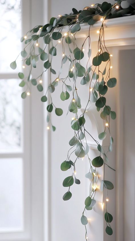 Elegant eucalyptus garland with twinkling lights on a fireplace, framing a white windowsill, creating a warm, soft glow. Christmas Decor With Eucalyptus, Christmas Boho Decor, Eucalyptus Christmas Garland, Eucalyptus Christmas Decor, Decorating With Fairy Lights, Boho Winter Decor, Christmas Greenery Decor, White Winter Decor, Christmas Eucalyptus