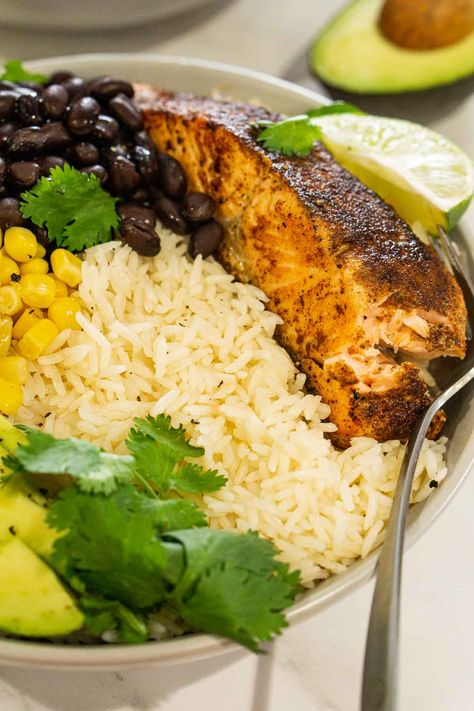 Tasty, filling, and super quick and easy to make, these Blackened Salmon Rice Bowls are a FAVORITE weeknight dinner. Super convenient and packed with flavor! Use blackened seasoning, cajun seasoning, or use taco seasoning for a non-spicy option. Serve with black beans, corn, avocado, or other favorite toppings (lots of ideas inside!). Definitely give this recipe a try if you're looking for quick family dinner ideas! Salmon Black Beans And Rice, Cajun Salmon Rice Bowl, Salmon And Black Beans, Blackened Salmon Bowl, Quick Family Dinner Ideas, Salmon Quinoa, Corn Avocado, Quick Family Dinners, Salmon Rice Bowl