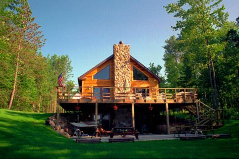 Chalet style home on a walk out basement with cedar siding and a stone chimney in the middle Chalet Plans, Lodge Style House Plans, Chalet Ideas, Chalet Style Homes, Custom Modular Homes, Basement House Plans, Stone Chimney, Deck Designs Backyard, Chalet Style