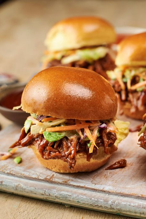 A close-up shot of a Brioche Slider Roll filled with pulled pork and slaw on a wooden board. Brioche Sliders, Pulled Pork Slaw, Creamy Slaw, Slider Rolls, Pulled Pork Sliders, Brioche Rolls, Pork Sliders, Tasty Dinner, Barbecue Pork