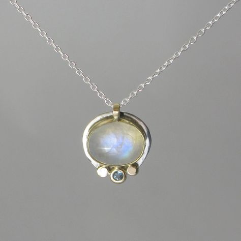 A smaller version of one of my best selling necklaces!! A gorgeous rainbow moonstone cabochon measuring 9 x 11mm is bezel set in a handmade 14k gold and sterling silver bezel setting. It's accented by a 3mm natural aquamarine** flush set in a hand made 14k gold nugget flanked by two plain gold nuggets. The design is understated... letting the gemstones be the focal point and giving the pendant a modern simplicity. The pendant is shown with a shiny/unoxidized finish in pics 1-3. Pic 4 shows the l Bezel Set Necklace, Moonstone Pendant Necklace, Moonstone Cabochon, Bezel Necklace, 14k Yellow Gold Necklace, Blue Topaz Necklace, Topaz Necklace, Gold Nugget, Bezel Pendant