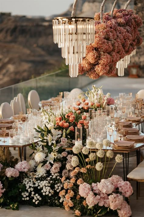 Flowers galore, a serpentine table, cliffside views, and opulent chandeliers created the most glam wedding reception in Mikonos, Greece | Image by Phosart Romantic Reception Decor, Glam Wedding Reception, Serpentine Table, Chic Wedding Venues, Wedding Layout, Reception Florals, Engagement Dinner, Table Arrangements Wedding, Floral Styling