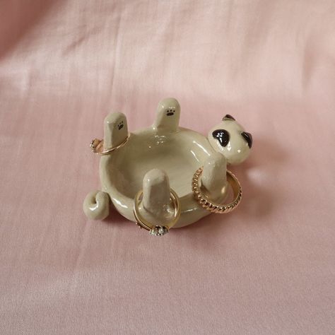 Pug jewellery holder/trinket dish. Handmade using air dry clay, painted and topped with a shiny varnish.  All products are unique and handmade by myself. Made with care and a special attention to detail ✨ Please note - since each product is hand crafted and hand painted, there may be small imperfections that make each piece unique and special.  💧Water resistant but not waterproof 💧 Dog Jewelry Dish, Clay Air Dry Diy, Clay Pottery Jewelry Holder, Usable Clay Projects, Practical Air Dry Clay Projects, Easy Clay Jewelry Dish, Useable Clay Projects, Dog Trinket Dish, Ceramic Art Jewelry Holder