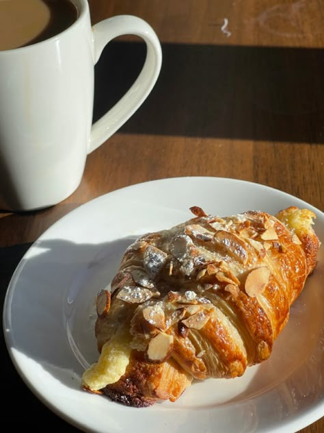 An almond croissant inside of a coffee shop next to a cup of coffee Almond Croissant, Paris Food, Food Babe, Food Platters, Cafe Food, Food Menu, Easy Snacks, Cute Food, No Bake Desserts