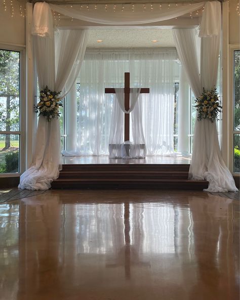 Getting ready for a ceremony at the altar with cross with drapery accent and beautiful flower tie backs. #houseestate #indoorceremony #houstonweddings Wedding Altar Indoor, Cross Backdrop Wedding, Cross Altar Wedding, Altar Flowers Wedding, Wedding Alters, Wedding Altar, Altar Flowers, Flower Tie, Wedding Cross