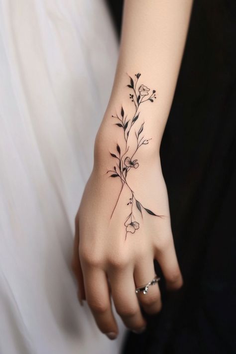 Delicate floral tattoo on wrist with minimalistic design. Tattoo For Girls Unique, Hand Tattoos For Women Unique Beautiful, Acotar Back Tattoo, Female Tattoo Ideas With Meaning, Hand Tattoos For Women Unique, Small Anchor Tattoos, Small Bee Tattoo, Tattoos For Women Unique, Tattoos Ankle