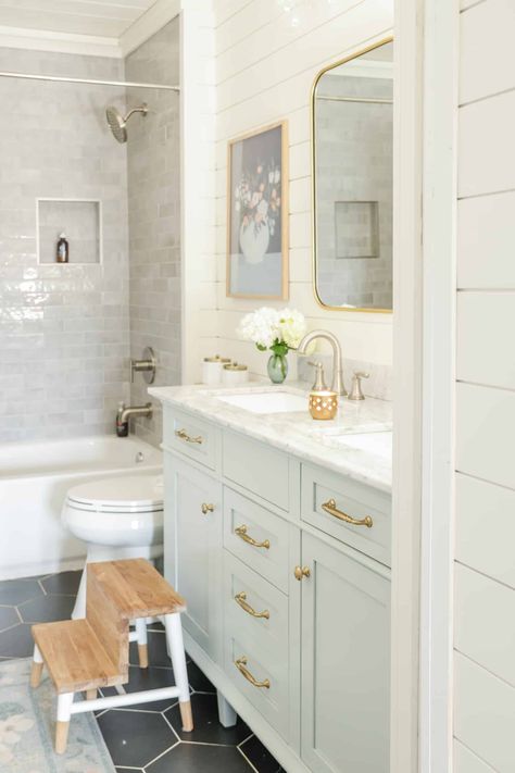 A small bathroom with a blue vanity. Kids bathroom with a pale blue vanity, gold hardware and black tile. Small bathroom ideas. Bathroom with shiplap. Main Bathroom With Laundry, Small Girls Bathroom Ideas, Blue Vanity Gold Hardware, Kids Bathroom Remodel Ideas, Kid Bathroom Remodel, Light Blue Vanity Bathroom, Kids And Guest Bathroom Ideas, Vanity Gold Hardware, Blue Kids Bathroom