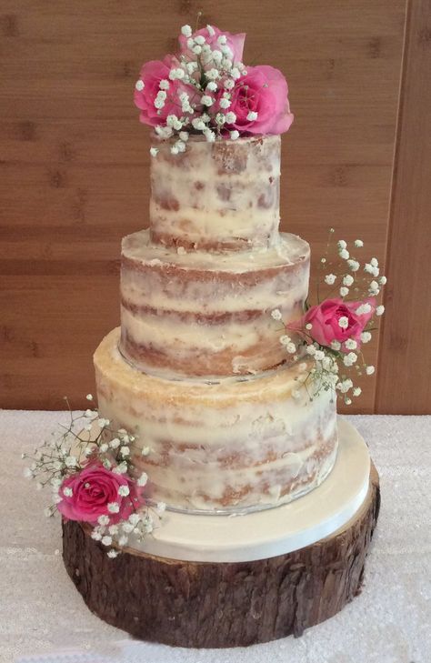 3 tier Semi Naked wedding cake with fresh roses and gypsophilia displayed on a log slice stand 3 Tier Naked Wedding Cake, Wedding Cake One Tier, Naked Wedding Cake With Flowers, Cake With Fresh Roses, Semi Naked Wedding Cake, Wedding Cake With Flowers, Cake With Flowers, Log Slice, Naked Cakes