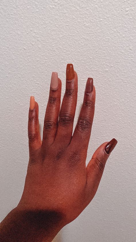 Black woman showing left hand in front of a white wall. Has multicolored acrylic nails. Thumb is a dark brown. Index is a light brown. Middle finger is a middle brown or tan. Ring finger is a very light almost gray brown and pinky is a pink and nude color. Nails Brown Skin Black Women, Autumn Nails Black Women, Fall Nails On Dark Skin, Multi Colored Fall Nails, Fall Nails For Black Women, Brown Nails On Black Women, Acrylic Nails For Black Women, Acrylic Nails On Black Women, Spring Nails Black Women