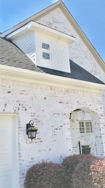 White Limewash Brick Exterior, Painted Brick Coastal Home, Brick Houses Painted White Before And After, Limewash Brick Exterior Before And After, Brick Houses Painted White, White Painted Brick Colonial, Oyster White Painted Brick Exterior, Limewash Brick Exterior, Stained Brick