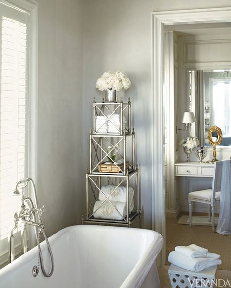 James Michael Howard - Gorgeous bathroom with pale gray walls and ivory moldings as well as soaking tub accented with floor mounted tub filler under window next to white garden stool and silver bathroom etagere. Master bathroom features separate dressing room with floating make-up vanity paired with French square back chair and inset mirror. Etagere Styling, Bathroom Etagere, Veranda Magazine, Silver Bathroom, Gorgeous Bathroom, Beautiful Bathrooms, New Classic, Amazing Bathrooms, Luxury Bathroom