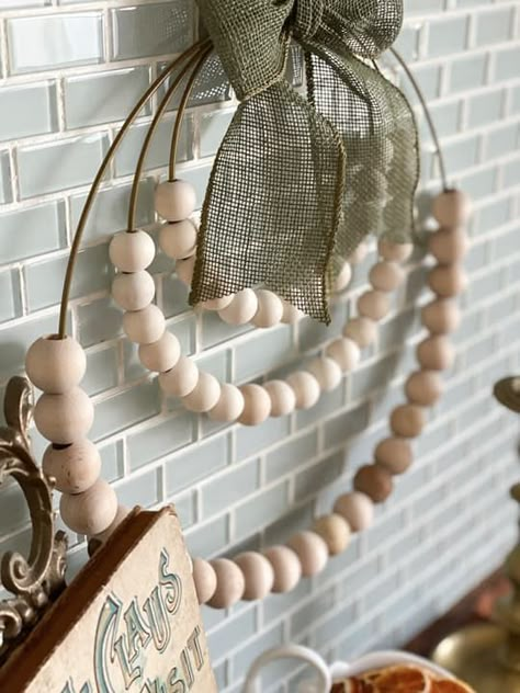 side Wood Bead Wreath Macrame, Diy Metal Wreath Ideas, Wood Bead Floral Wreath, How To Style Bead Garland, Oval Wall Decor, Diy Wooden Wreath, Beaded Garland Decor Ideas, Square Wire Wreath Ideas, Beaded Wreath Ideas