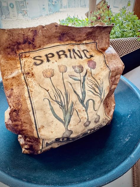 Tracey Campbell, from MySweetHomeLiving, shares an easy craft idea for creating primitive style spring garden bulbs, using a basic gift bag and a printable label...These make sweet & charming touches to any SPRING primitive farmhouse style decor. Primitive Shelf Decor Ideas, Primitive House Decorations, Primitive Shelf, Shelf Decor Ideas, Primitive Spring, Primitive Signs, Garden Bulbs, Primitive Style, Primitive Farmhouse