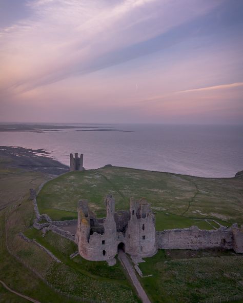 Lilac sunset skies over Dunstanburgh Castle 💜 Once the largest castle in Northumberland, Dunstanburgh is still a magnificent sight even today! Built in the 14th century between the villages of Craster and Embleton on part of the Great Whin Sill which took advantage of the site’s natural defences and the existing earthworks of an Iron Age fort. The castle formed a strategic northern stronghold in the region during the Wars of the Roses, but never recovered from the sieges of these campaign... Lilac Sunset, Dunstanburgh Castle, Sunset Skies, Wars Of The Roses, The Villages, Iron Age, Sunset Sky, The Castle, 14th Century