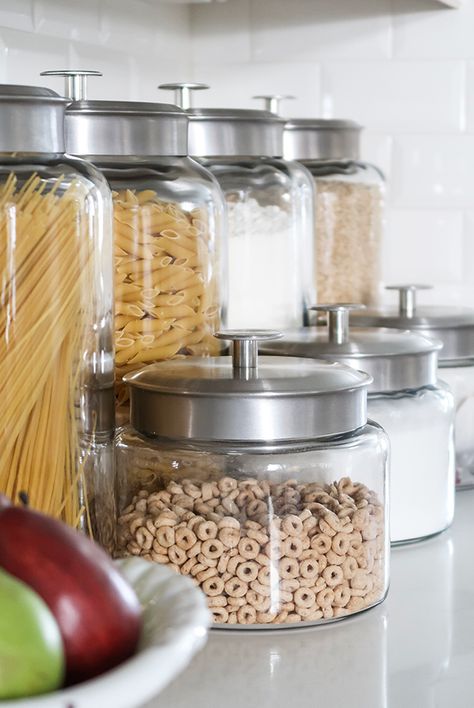 Looking to organize your kitchen and free up cabinet space? Try a counter top glass jar pantry. Store bulk items in airtight containers and clear kitchen counter clutter. #smallkitchenorg #declutterkitchencounters #generalstorepantry #jarpantry #kitchenideas #kitchencounters #smallkitchenideas #porchdaydreamer Glass Jars For Kitchen Storage, Kitchen Glass Jars Display, Glass Canisters In Kitchen Display, Kitchen Jars Decor Display, Glass Jars Kitchen Counter, Men Cupcakes, Jar Pantry, Storage Jars Kitchen, Kitchen Dining Room Combo