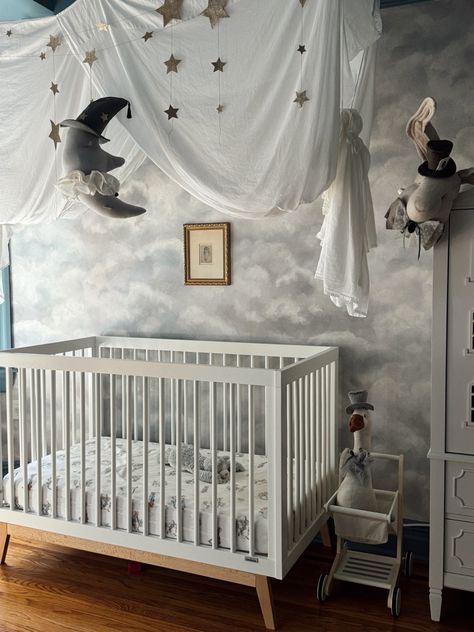 whimsical nursery with soft cloud wallpaper, cozy blankets, and celestial accents, creating an enchanted and peaceful space for a newborn Celestial Mobile, Wooden Shopping Cart, Enchanted Nursery, Celestial Wallpaper, Celestial Nursery, Cozy Textiles, Playful Decor, Nursery Design, Nursery Ideas