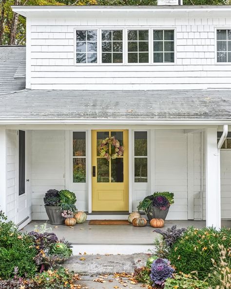 white farmhouse with covered porch and yellow front door decorated for fall with dried hydrangea wreath, pumpkins cabbages Houses Futuristic, Yellow Front Door, Houses Modern, Yellow Front Doors, Best Front Doors, Farmhouse Exterior Design, Front Door Paint Colors, 40 Acres, Yellow Door