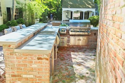 Brick patio with built-in outdoor kitchen and dining spaces. Design includes stainless steel appliances and built-in bar with cafe chairs and metal and glass outdoor dining table with folding chairs. #brick #brickpatio #outdoordining #outdoorcooking #outdoorkitchen #outdoorspace #patiodesign #patiofurniture #outdoorbar #cookingoutdoors #builtinkitchen #builtinoutdoorkitchen #builtingrill #builtinbarbecue #barbecuegrill #grilling #brickkitchen #patio #landscapearchitecture #landscapedesign Outdoor Brick Kitchen Ideas, Brick Outdoor Bar, Outdoor Brick Kitchen, Rectory House, Brick Built Bbq, Brick Outdoor Kitchen, Outdoor Kitchen And Dining, Backyard Grill Ideas, Kitchen Ideas Outdoor