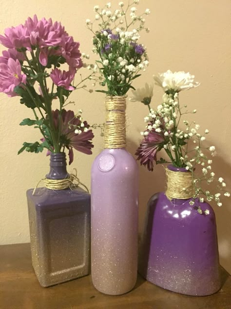 DIY centerpieces. Old alcohol bottles, spray paint, twine- DONE Old Alcohol Bottles Diy, What To Do With Old Alcohol Bottles, Diy With Alcohol Bottles, Painting Liquor Bottles Diy, Alcohol Bottle Crafts Diy Ideas, Alcohol Bottle Centerpieces Wedding, Diy Alcohol Bottles Crafts, Old Alcohol Bottles, Alcohol Bottle Crafts