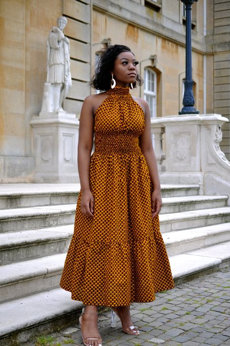 Our dark mustard yellow halter kneck African print maxi dress is beautiful for the summer/spring weather featuring an elasticated top half to adjust to any body type or shape for a nice fit and a flowy bottom that makes the dress breathable.This dress is suitable for any occasion, it can be styled nicely with gold jewellery for a finishing touch. 100% African wax cotton  Fits true to size  The product is lined  Elasticated top half for a good fit around the top half of body We also make custom m African Shirt Dress, Ankara Maxi Dress, Bright Color Dresses, Dress African, African Shirts, Ankara Style, Ankara Dress, Printed Long Dresses, Halter Maxi