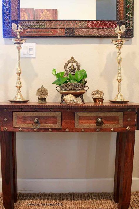 An entryway table from Pier 1 Imports stands below the mirror. Two annapakshi twin lamps stand on either side with a Ganesha uruli in the center. Entryway Decor Indian, Study Table Decor, Indian Room Decor, Home Decor Indian, India Home Decor, Console Table Decorating, Indian Interiors, Entryway Table Decor, Home Decor Blog