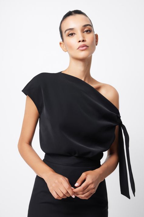 Imbued with a modern, minimalist appeal, The Drop Off Top is a sophisticated staple piece designed to take you from desk-to-dinner. In a classic shade of black, this design features an asymmetric neckline with a unique shoulder tie. This relaxed fit blouse delivers a fresh perspective for the modern woman. Features: Tie shoulder Off the shoulder Long-line Unique Top Designs For Women, Modern Minimalist Style Fashion, Tailored Tops For Women, Modern Tops For Women, Fashion Tops Blouse Unique, Fashion Tops Blouse Style, Asymmetrical Tops For Women, Formal Skirt Outfit, Asymmetrical Top Outfit