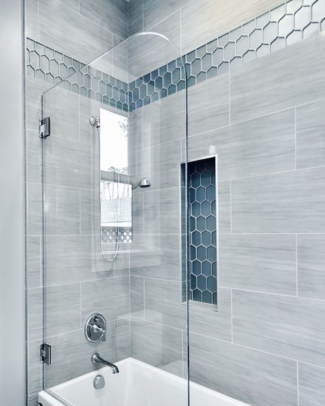 A gorgeous pop of blue really shines in this beautiful, spa-like shower. #showerdesign #showers #showertile #bathrooms #bathdesign #interiordesign #bathrooms #shower #interiors Master Shower Rain Head, Bathroom Shower Tiles Gray, Small Shower Tub Ideas, Bathroom Blue Shower Tile, Walk In Shower With Blue Accent Tile, Blue Glass Tile Bathroom Showers, Beach House Condo Interior, Blue Bathroom Tiles Shower Ideas, Large Blue Shower Tile