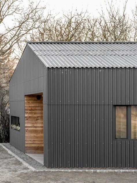 Black Corrugated Fiber-Cement Siding Almost Completely Covers The Exterior Of This New Home Corrugated Fibre Cement Cladding, Corrugated Cladding, Corrugated House, Metal Siding House, Modern Black House, Black Cladding, Corrugated Metal Siding, Fibre Cement Cladding, Black Window Frames