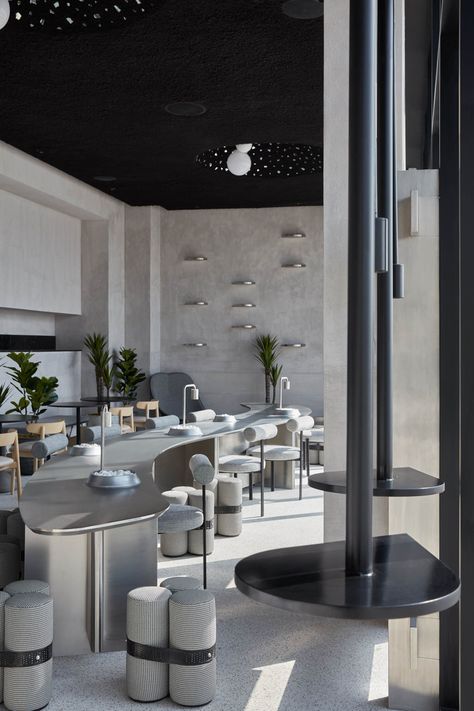 Dubai-based studio Roar designs a sophisticated monochrome and textured coffee shop for Drop Coffee in Abu Dhabi. A stainless-steel communal table snakes down the center of the café. Dark Painted Ceiling, Greenwich Village Apartment, Unique Cafe, Grey Interior Design, Communal Table, Cafe Shop Design, Cafe Tables, Shades Of Gray, Gray Interior