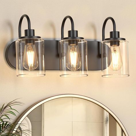 This 3-Light black bathroom light fixture is the perfect addition to any modern or farmhouse home decoration! Unlike other traditional design, this bathroom sconce wall lighting features an oval shaped backplate design. Crafted from durable matte black lamp body with clear glass shades, they are ideal for adding a touch of style to your bathroom mirror, bedroom, living room, or dressing table. Good choices for home decoration! #ad #amazon #farmhouse #bathroomdecor #lightfixture Matte Black Bathroom Vanity Light, Bathroom Vanity Lighting Over Mirror Black, Matte Black Bathroom Light Fixtures, Black Bathroom Light Fixture Over Mirror, Black Vanity Lights Bathroom, Bathroom Light Fixtures Black, Black Vanity Lights, Bathroom Amazon, Black Bathroom Light Fixtures