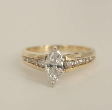 You are bidding on a beautiful 14k yellow gold Marquise Diamond Wedding Ring! This ring is stunning and has one big Marquise cut diamond set in a high setting. This diamond is beautiful and is approximately 0.35ct. There are also ten round cut real diamonds on the side of the marquise that are set in a channel set setting. Those ten diamonds come to approximately 0.20ct. So in total there is approximately 0.65ct of real diamonds in this ring.    The dark spots that can be seen in some of the pic Channel Set Marquise Engagement Rings, V Prong Engagement Ring, Engagement Rings With Small Diamonds, Gold Engagement Ring Small Diamond, Engagement Ring Engraved Band, Vintage Unique Wedding Rings, Inlaid Engagement Ring, 70s Engagement Ring, Wedding Bands For Marquise Ring